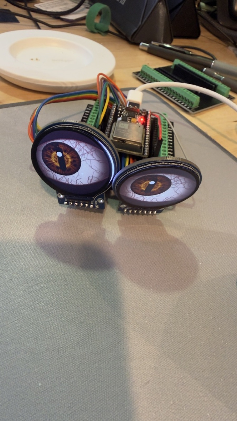 Two round displays on the same kind of board, each showing an animated eye